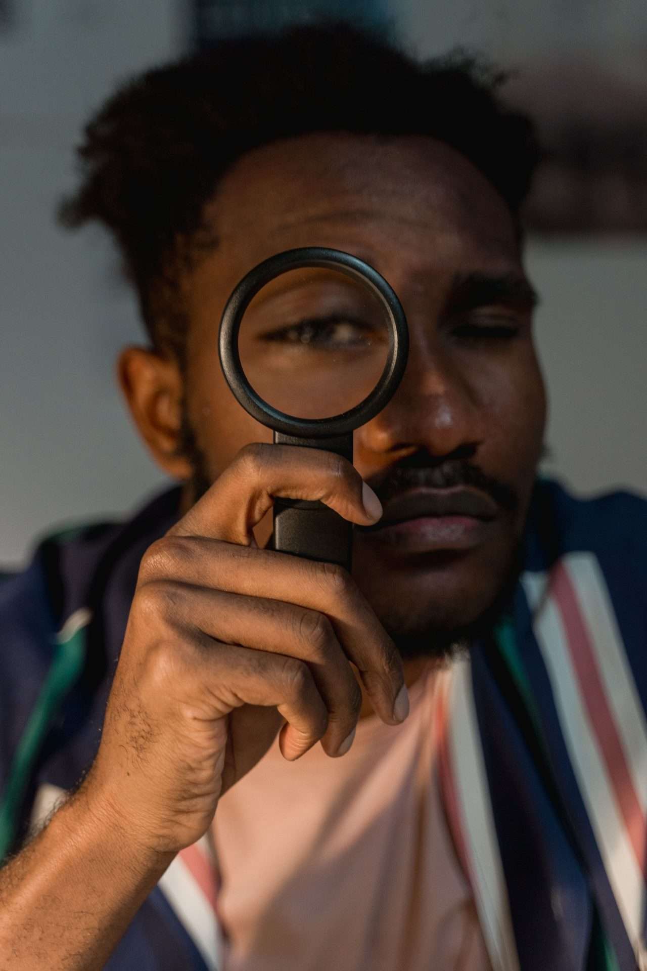 Man looking closely through a magnifying glass